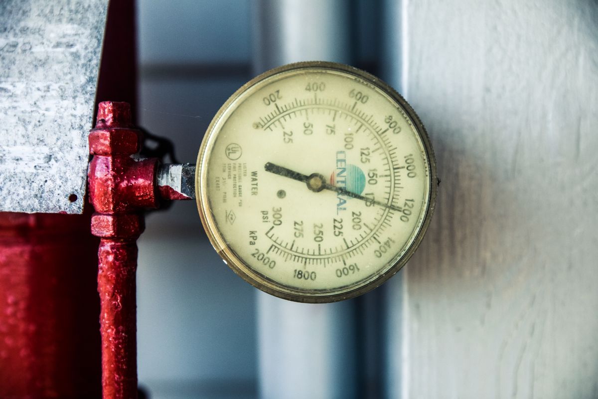 America’s Power Bills Are Rising Faster Than Inflation, and Bigger Hikes May Be Coming 2 Detailed view of a pressure gauge attached to a red industrial pipe, measuring PSI and kPa.