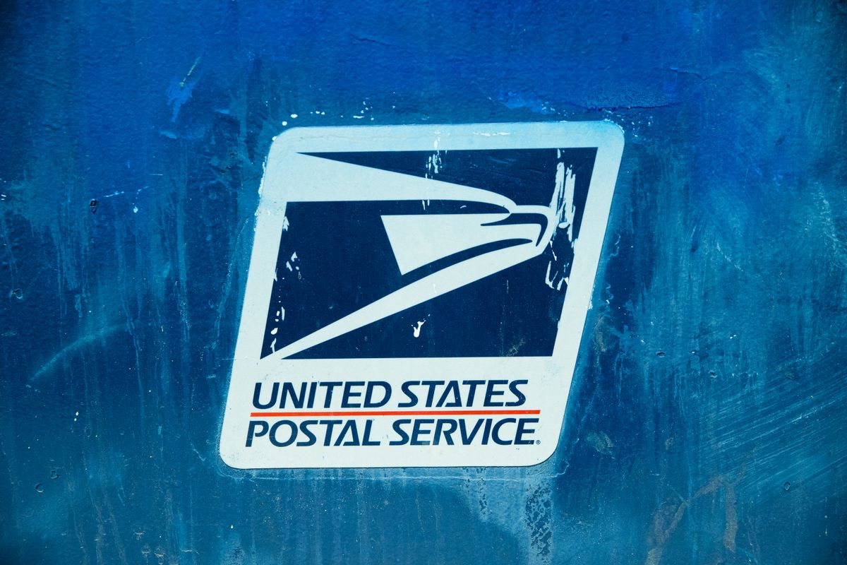 North Carolina postal worker Brandi Reynolds was killed while delivering mail in Hays County. 4 Detailed view of the United States Postal Service logo on a blue background, showcasing texture.
