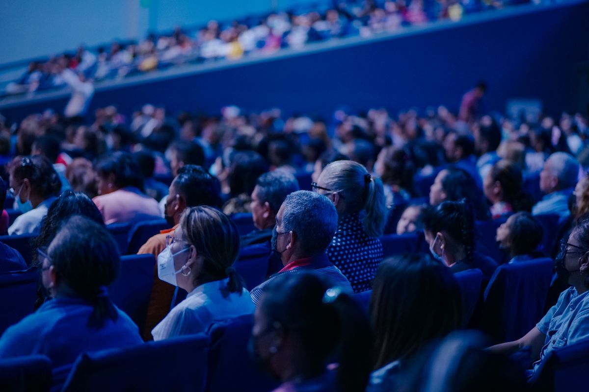 Community Impact 101: How Businesses Are Quietly Reshaping Local Communities (and Why It Matters More Than Ever) 3 Diverse audience sitting in rows, attending an indoor conference or event.