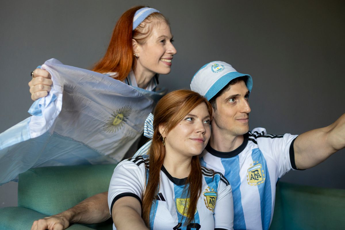 Argentina World Cup Controversy Deepens as Fans Question Whether Football’s Biggest Stage Is Truly Fair 2 Fans wearing Argentina jerseys cheer while watching a match indoors. Captured in Buenos Aires.