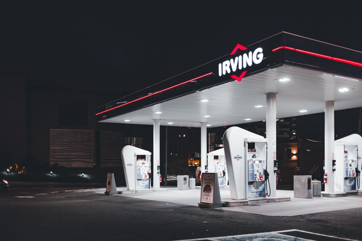 Illuminated Irving gas station at night, showcasing modern design and bright lighting.