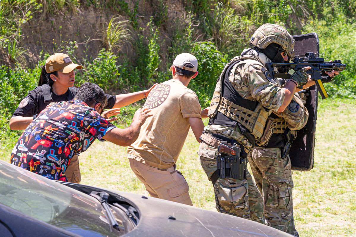 Military personnel in outdoor exercise, showcasing tactical and defensive skills with civilians.