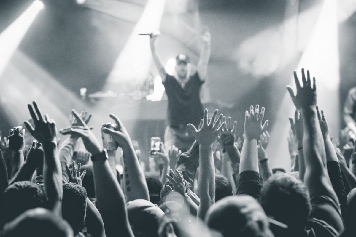 Monochrome photo capturing a vibrant live concert atmosphere with an engaging audience.