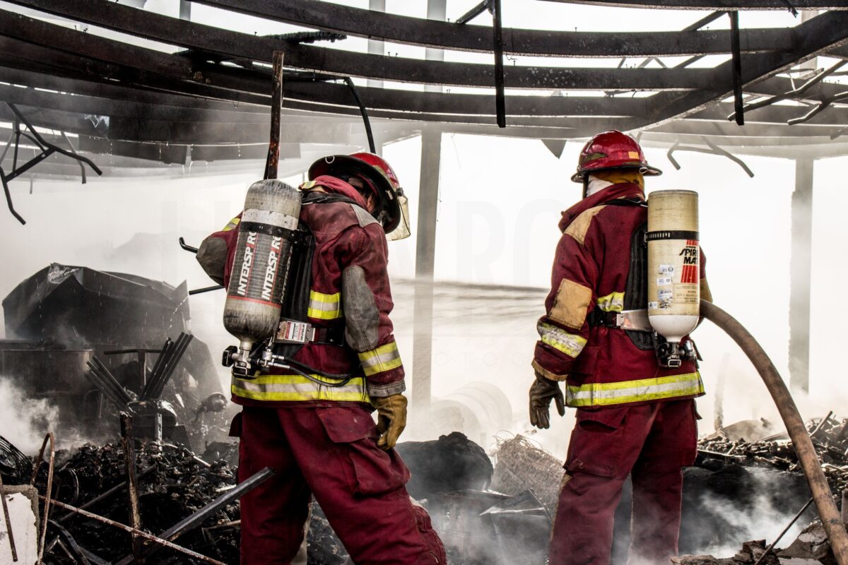 two-firefighters-standing-in-a-burned-down-building