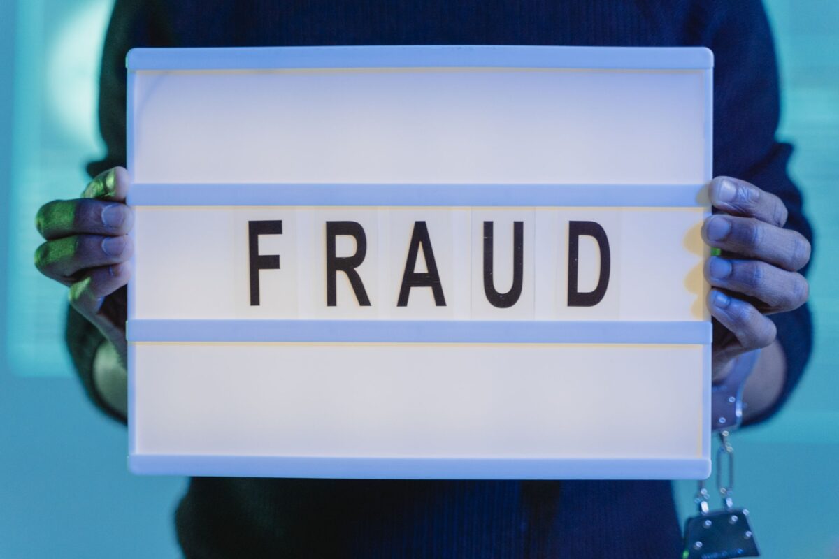 Police Warn Bitcoin ATM Scams Are Draining Arizona Residents’ Savings as Criminals Exploit Crypto Machines. 3 a-person-with-handcuffs-holding-a-sign-that-says-fraud