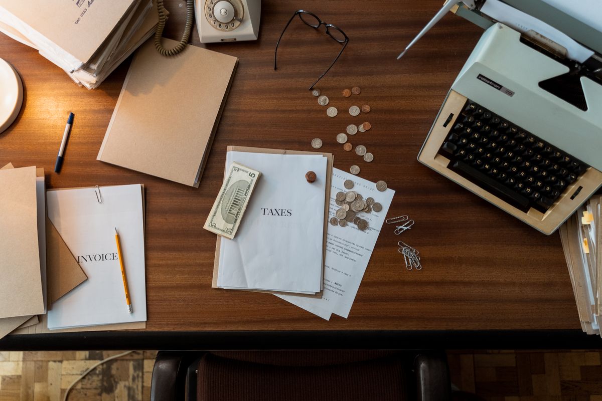 Texas Apartment Owners Are Facing a Perfect Storm as Billions in Real Estate Bets Begin to Crack 2 Retro office scene featuring a typewriter, coins, documents, and stationary on a wooden desk.