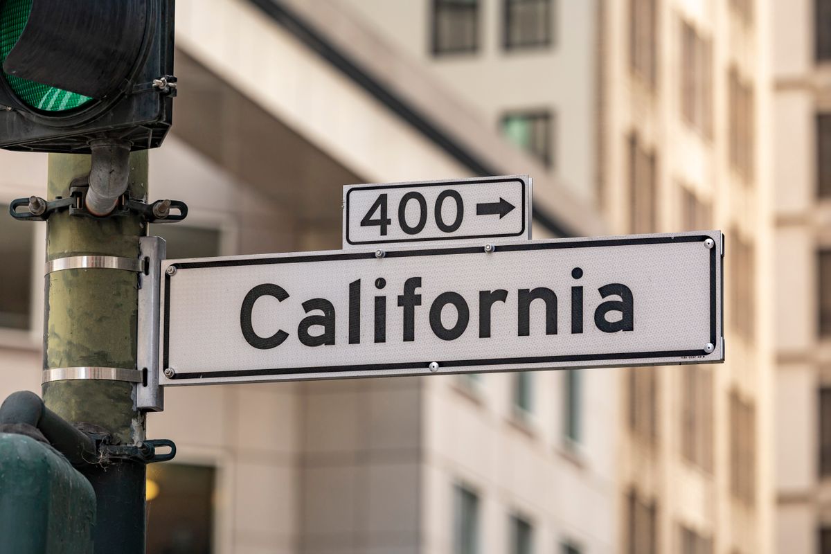 Street sign for California with traffic light in cityscape. Urban navigation and signage theme.