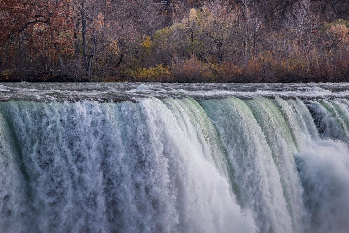 Couples Are Rethinking These “Dream” Honeymoon Spots After Seeing the Real Price Tag 1 Stunning autumn scene of Niagara Falls with vibrant foliage in the background.