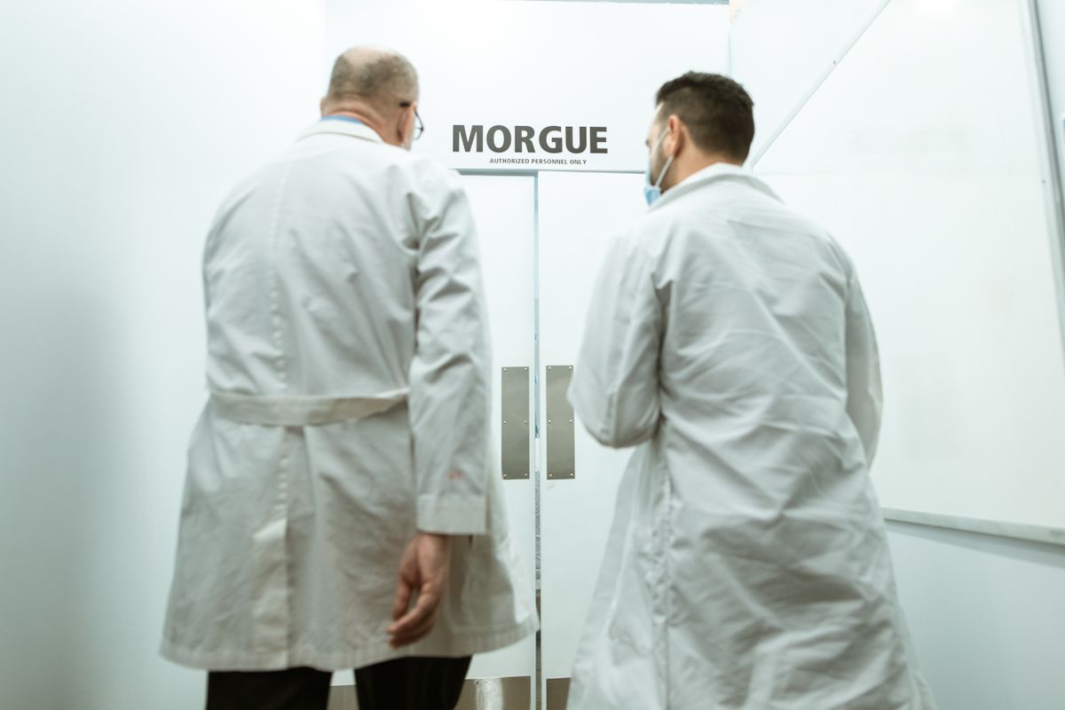 Two doctors entering a morgue, emphasizing a clinical and somber atmosphere.