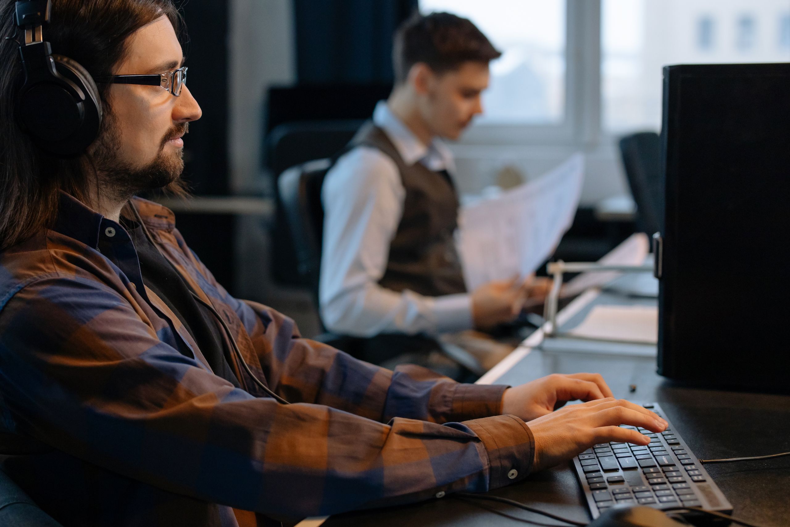 NYC’s Welfare Bill Hits $2.7 Billion as Nearly 865,000 Receive Cash Aid. Is the Safety Net Becoming Permanent? 2 Two office workers focused on tasks at their desks in a modern workspace.