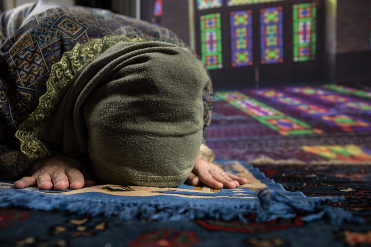 Muslim woman praying for Allah muslim god at the mosque. Hands of muslim woman on the carpet praying in traditional wearing clothes, Woman in Hijab.