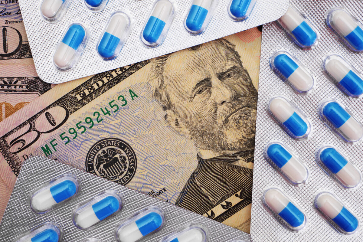 The Medicaid Money Fight: Why Critics Say Some States Are Playing Games With Billions in Federal Funds 1 Top view on blue and white pills in blister pack on dollar banknotes