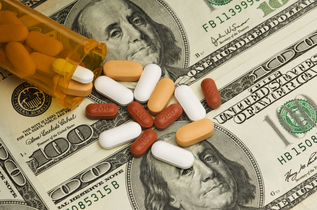 The Medicaid Money Fight: Why Critics Say Some States Are Playing Games With Billions in Federal Funds 2 A variety of pills spilled over American $100 dollar bills.