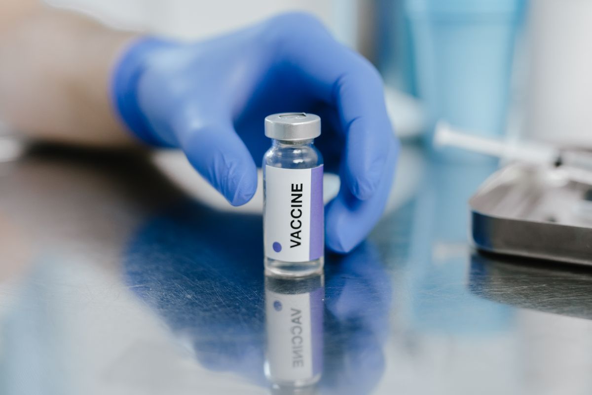 RFK Jr.’s CNN interview exposed a dangerous health crisis Americans cannot ignore 2 A gloved hand holding a vaccine vial in a medical setting, symbolizing healthcare.