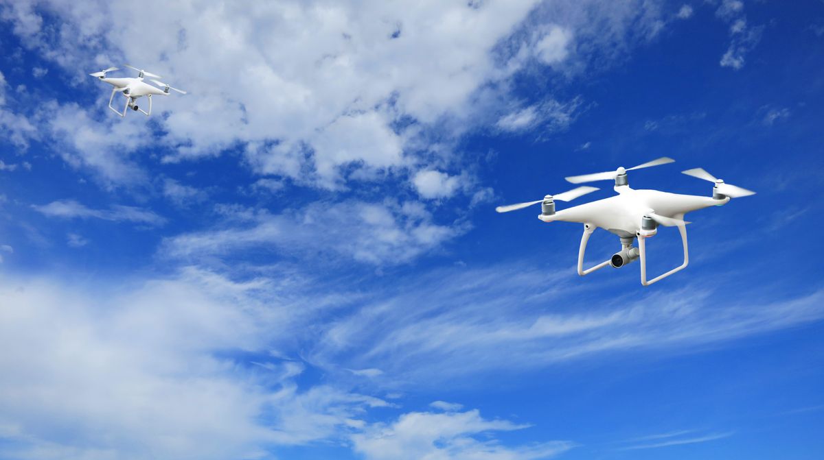 700 Drones Seized Near World Cup Events, but White House Says None Were Weaponized 2 A stunning capture of two drones flying against a bright blue sky with soft clouds.