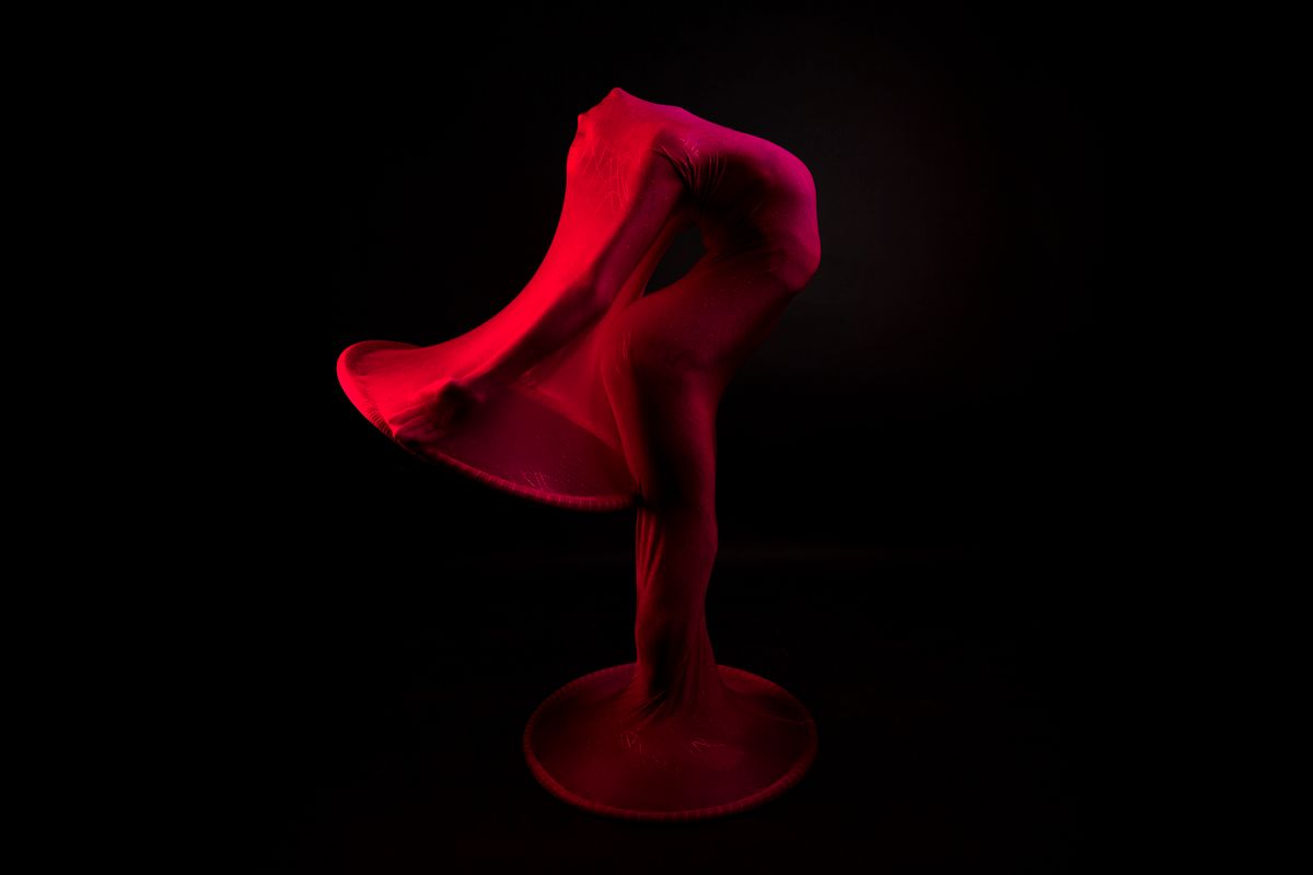 Ariana Grande Quits West End Role as America’s Celebrity Machine Pushes Too Far 2 Abstract image of a dancer wrapped in red fabric, creating a dynamic artistic pose.