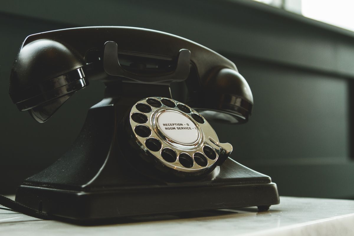 Delaney Hall detainee death exposes the human cost of a $1 billion system. 1 Classic black rotary phone on hotel reception desk, evoking nostalgia and vintage charm.