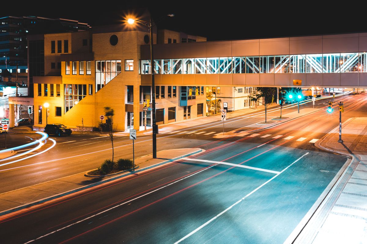 Stamford Plans $5 Million Glenbrook Intersection Overhaul to Improve Safety and Traffic Flow 2 Long exposure asphalt road running between contemporary urban buildings with pedestrian overpass at night
