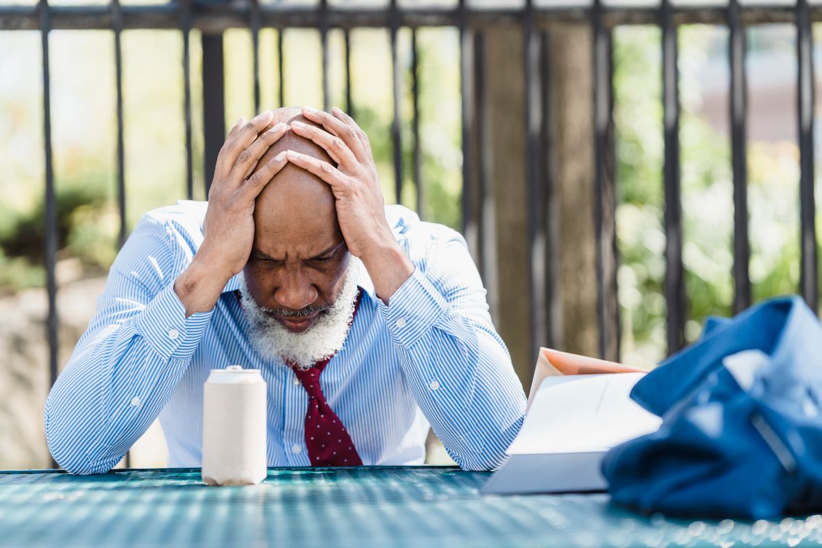 7 Brutal Reasons So Many Americans Are Rethinking the 9-to-5 1 Mature man looking troubled while sitting outdoors, related to business stress.