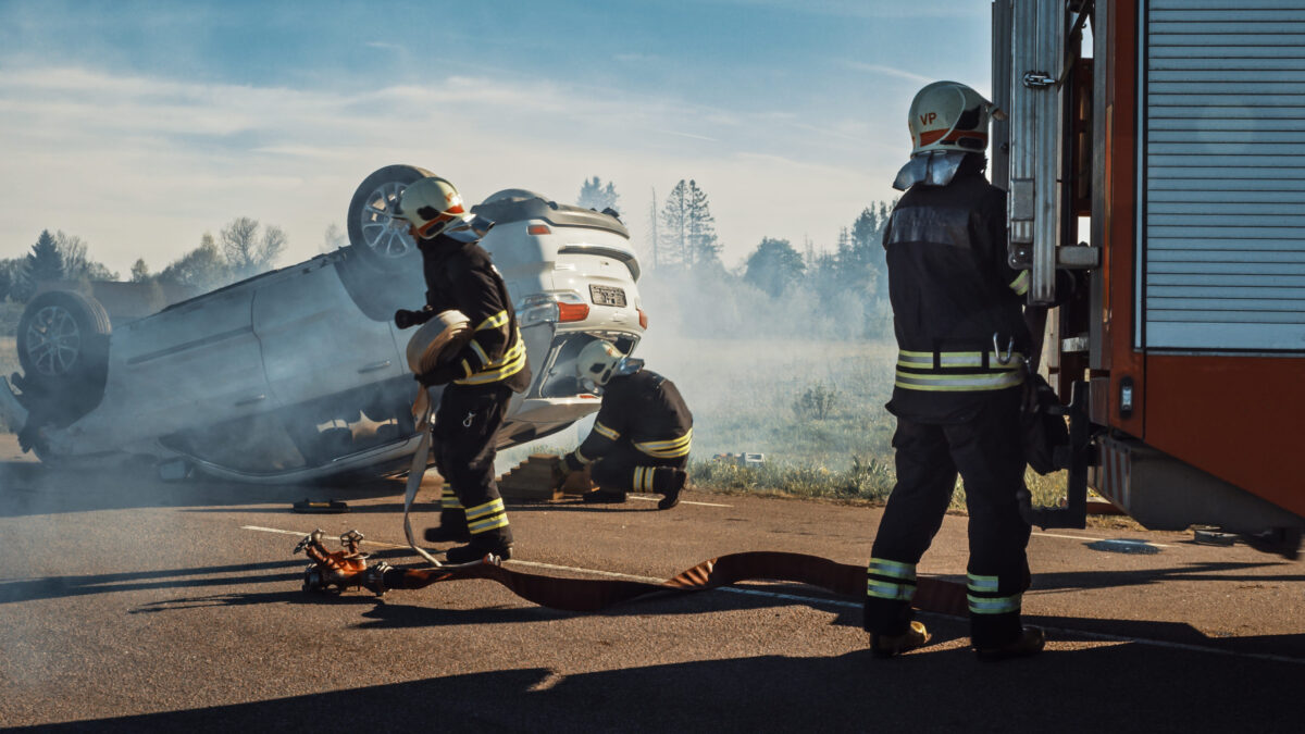 Driver Rescued After Early Morning Rollover Crash in Melrose 1 Rescue Team of Firefighters Arrive at the Crash, Catastrophe, Fire Site on their Fire Engine. Firemen Grab their Equipment, Prepare Fire Hoses and Gear from Fire Truck, Rush to Help Injured People.