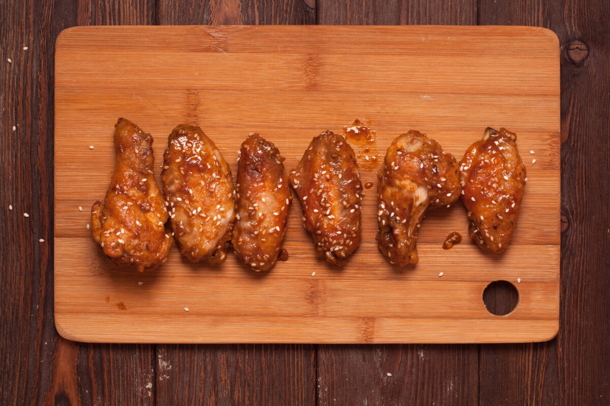 Chicken wings: honey, sesame, ginger. on a wooden table.
