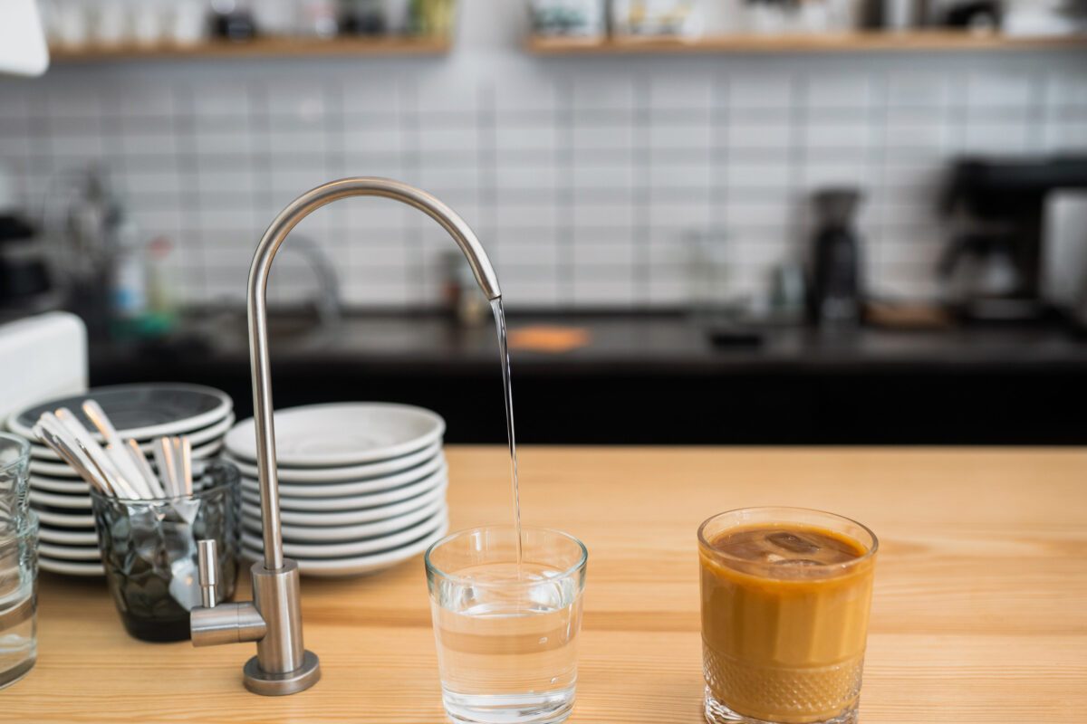 water is pouring from a tap into a glass