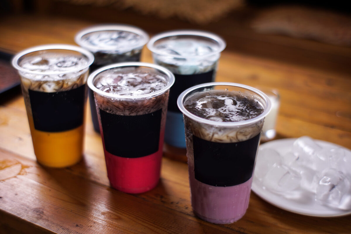 variant of cold drinks with fruit flavor. fresh cafe menu with dark background. colorful ice mockups with plastic cups. grape, chocolate, strawberry, mango, grass jelly, blueberries, guava