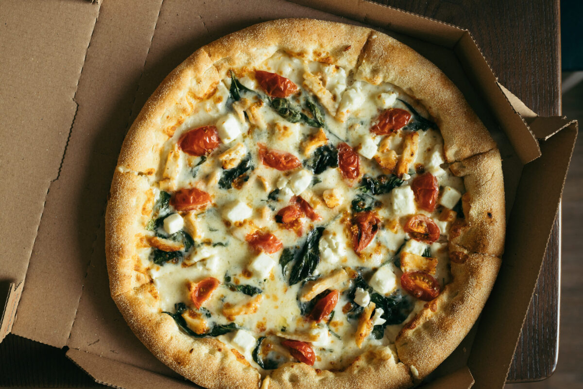 7 Easy Ways to Make Frozen Pizza Taste Surprisingly Amazing 1 Pizza in box on the table. Top view.