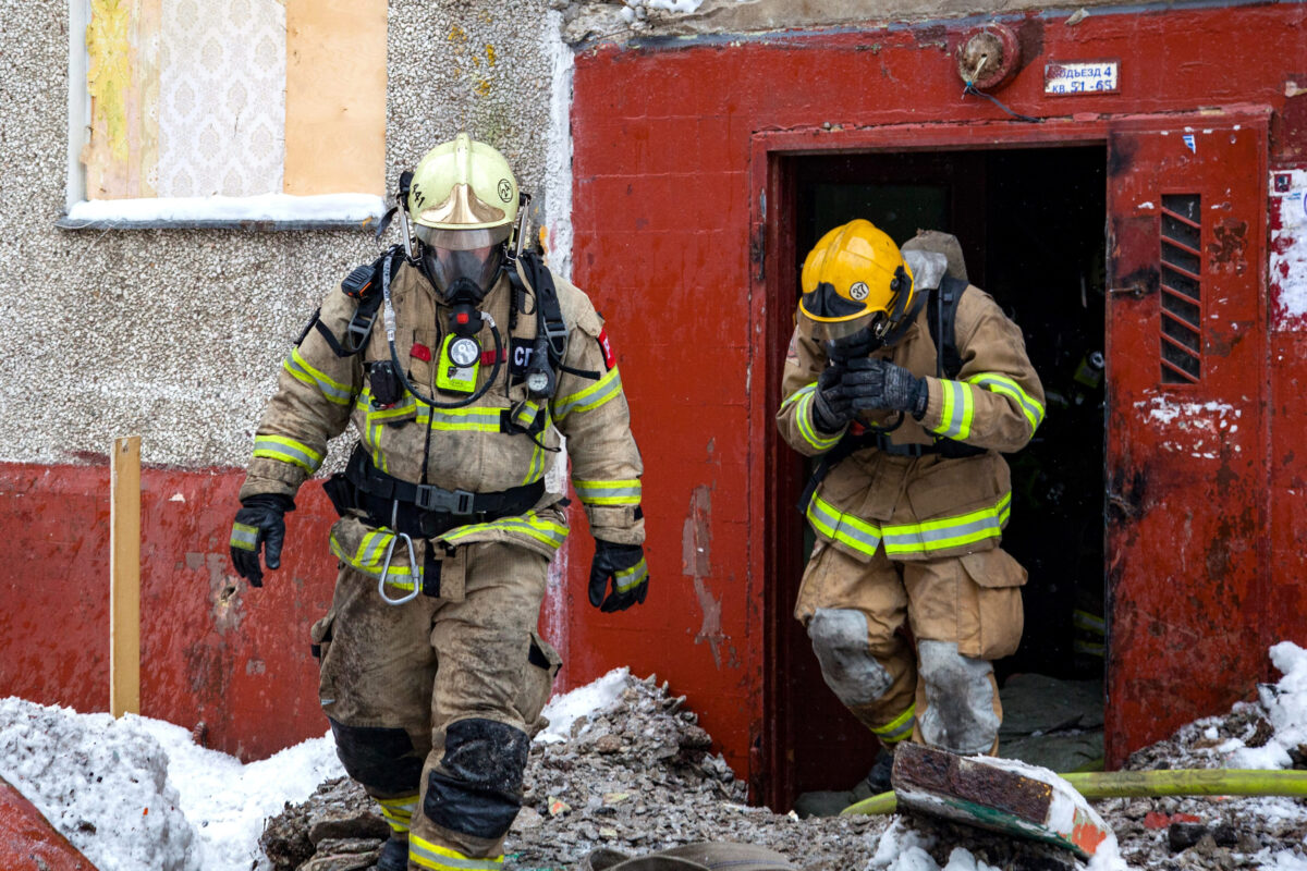 Three firefighters extinguish a fire in an apartment house