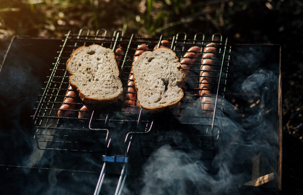 Burning firewood in a homemade barbecue on background in garden. Firewood, fire and smoke close-up