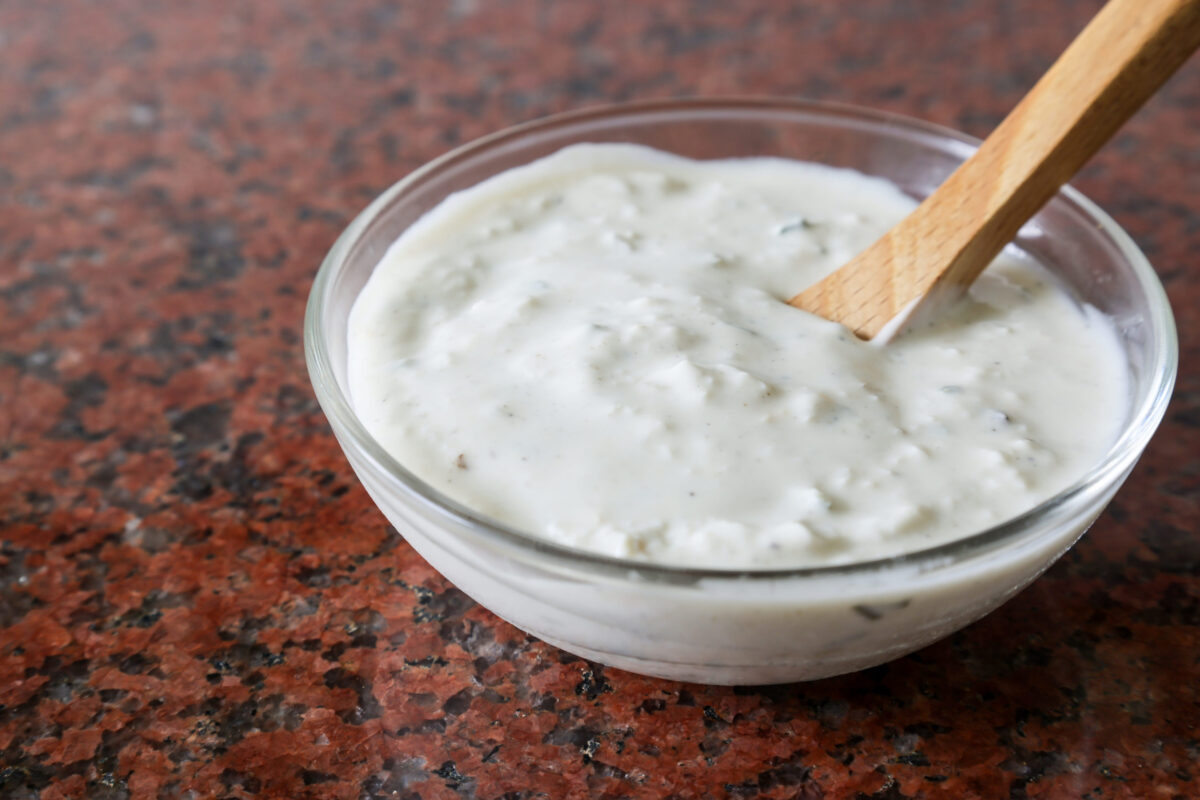 Tartar sauce in the glass bowl isolated on the marble plate.