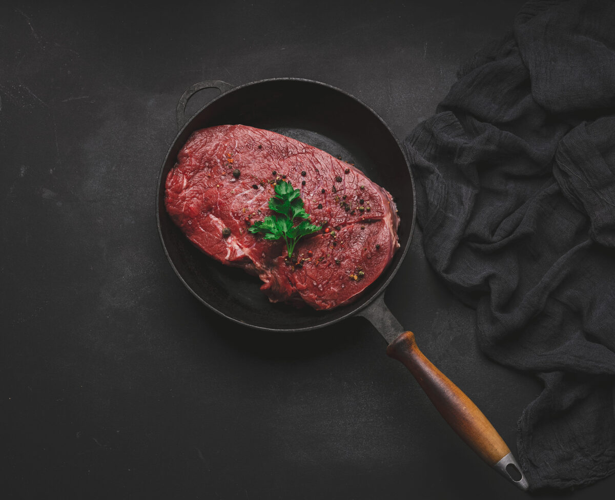 How to Make a Proper Beef on Weck: The Buffalo Sandwich That’s All About Balance 2 Raw beef tenderloin lies in a metal round frying pan on a black table, top view