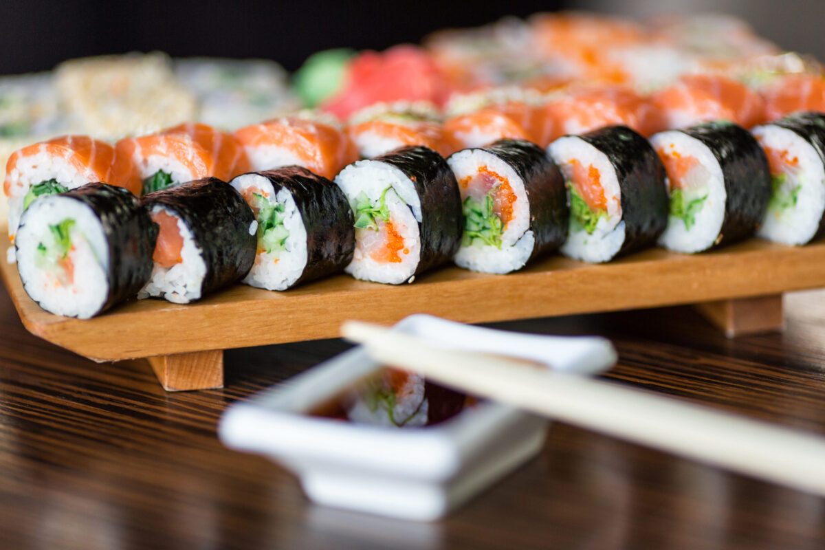 Sushi rolls served on a wooden plate in a restaurant
