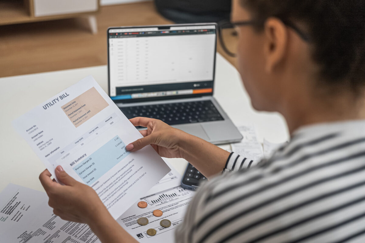 What Moraine Valley’s $115 Million Bond Referendum Means for Voters 2 Concentrated woman examines documents with utilities for payment sitting at table with laptop in light office female studies data on papers in accommodation