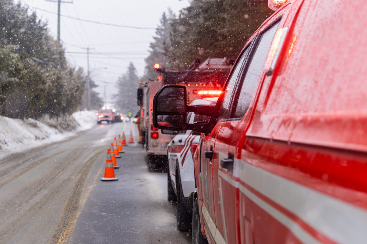 Firefighters and police officers are intervening on a snowy road during a winter snowstorm. Selective focus
