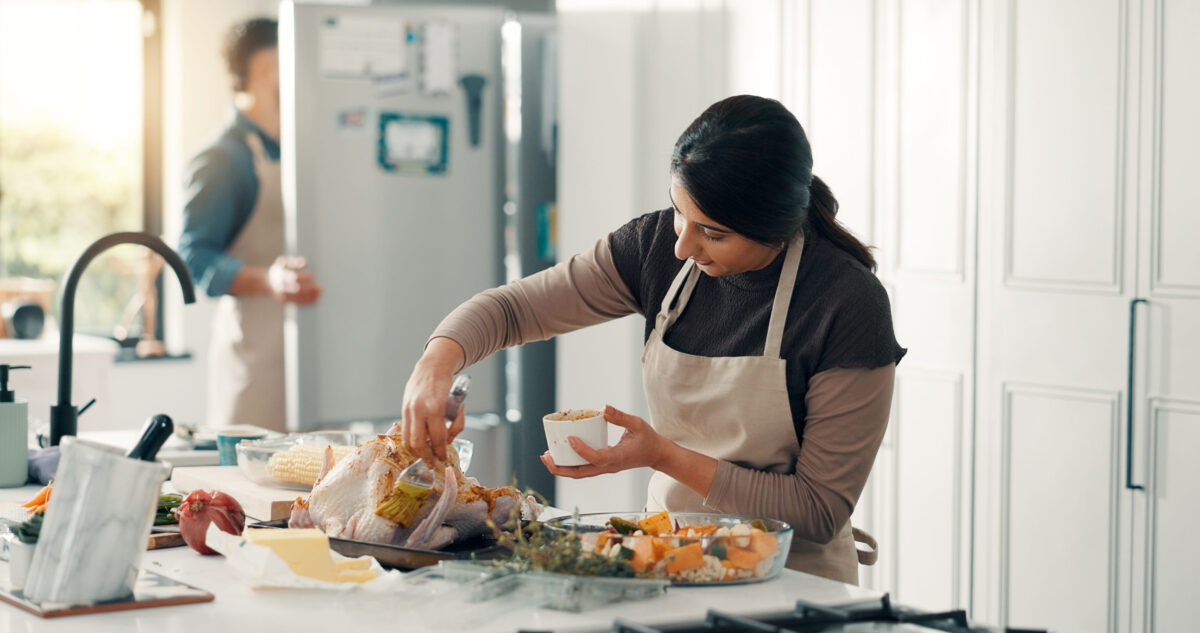 Woman, chicken and meal prep with brush kitchen for thanksgiving recipe or marinade in home. Female person, chef and preparation with turkey, sauce or ingredients for flavor or seasoning in house