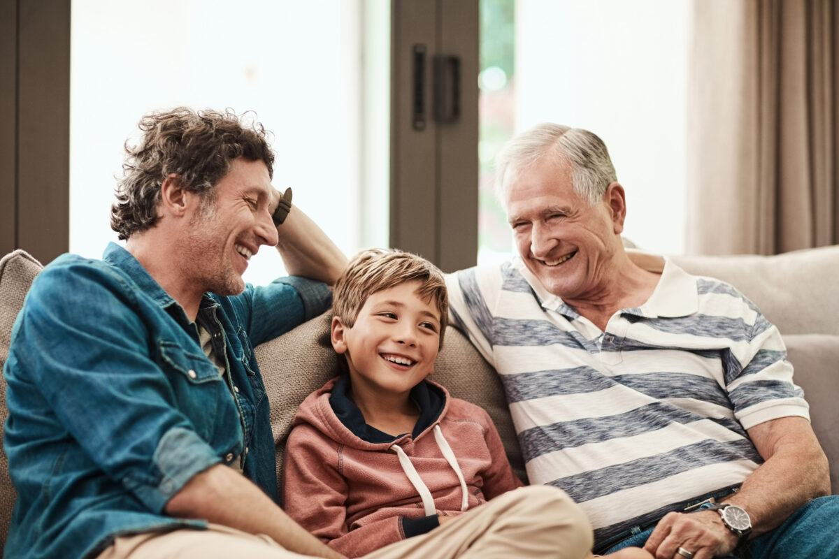 Father, son and grandfather with smile on sofa with love, generations and bonding in house. Happy men, child and relax in family home with laugh, funny joke and together for visit in living room.