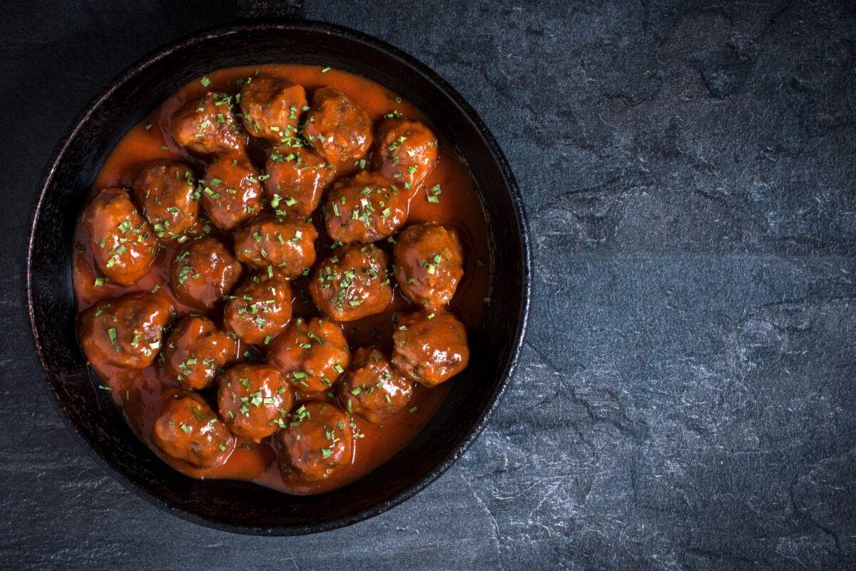 Meatballs with tomato sauce in the pan on dark background,blank space on the right side