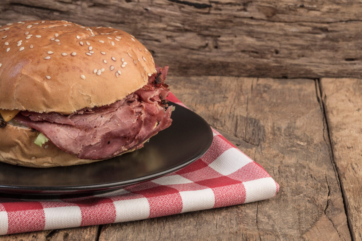 A delicious roast beef burger on wooden table