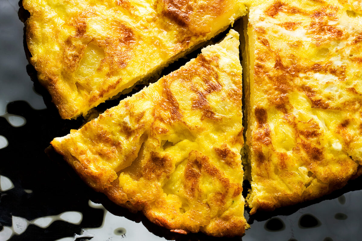 Top view close up of sliced omelet on black plate