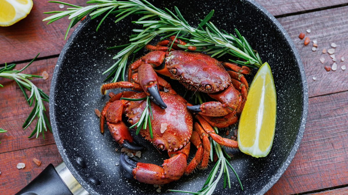 Cooked crabs with rosemary, lemon and sea salt in a skillet