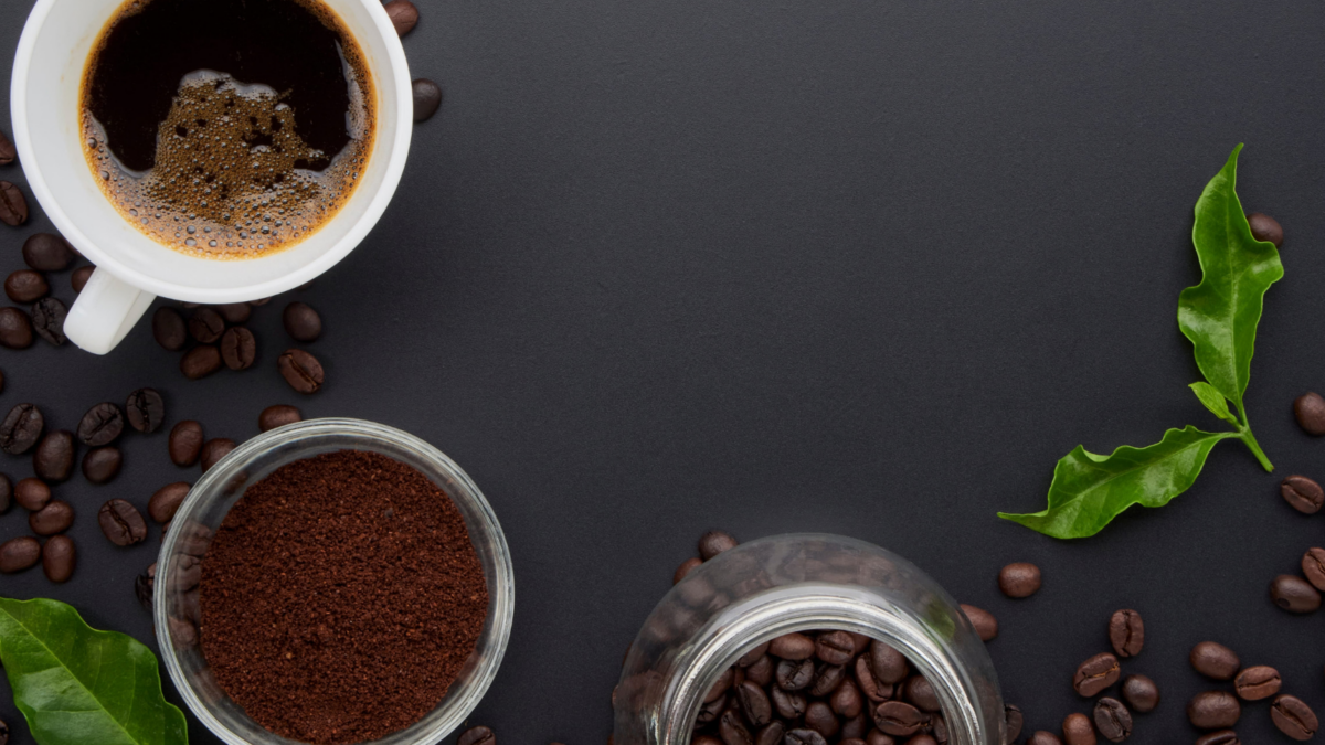 Coffee cup with roasted coffee beans, ground coffee powder and coffee leaves on black background. Image Credit: 
19lion/ 123RF