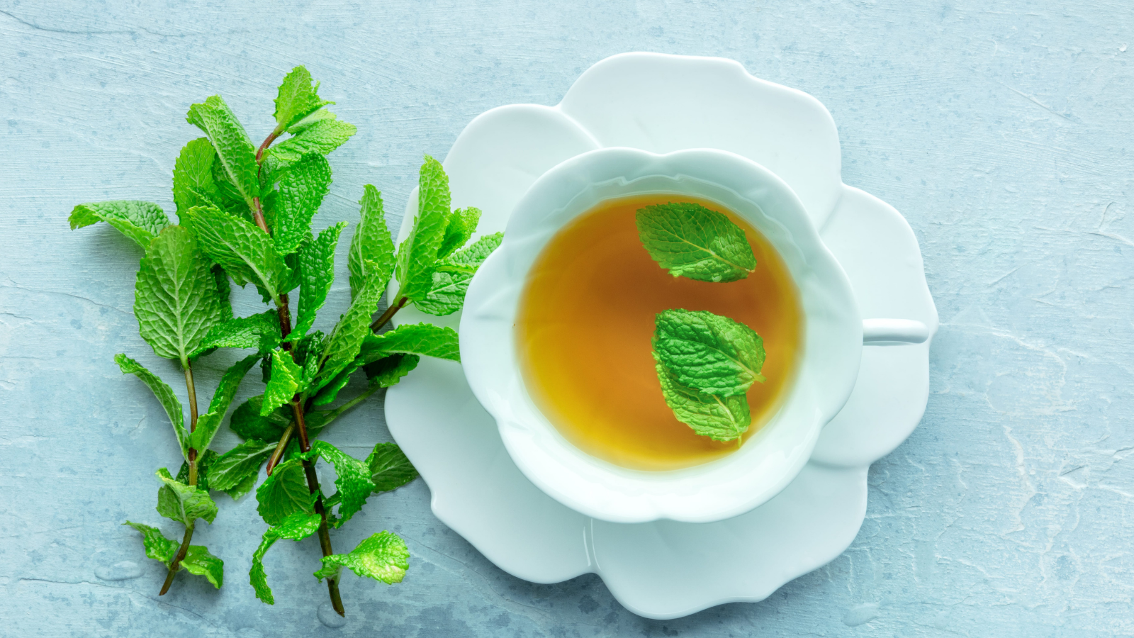 A cup of peppermint tea with fresh mint leaves