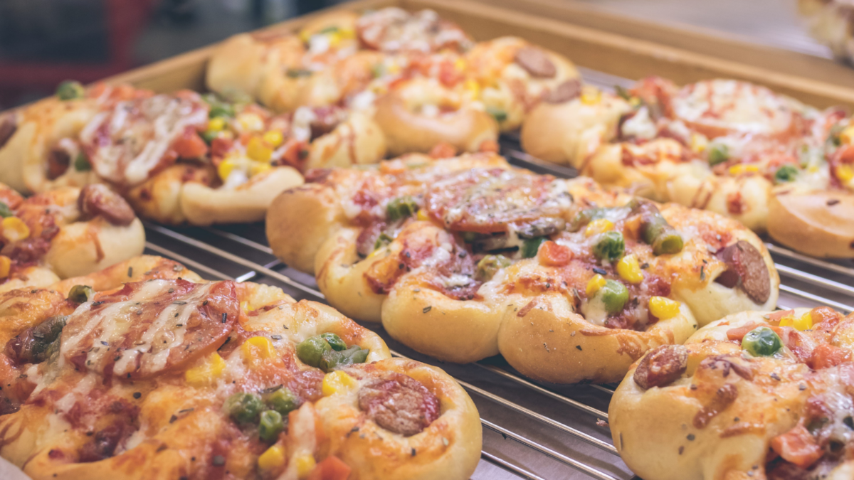 Mini pizzas with cheese, tomato, green beans, corn and sausages