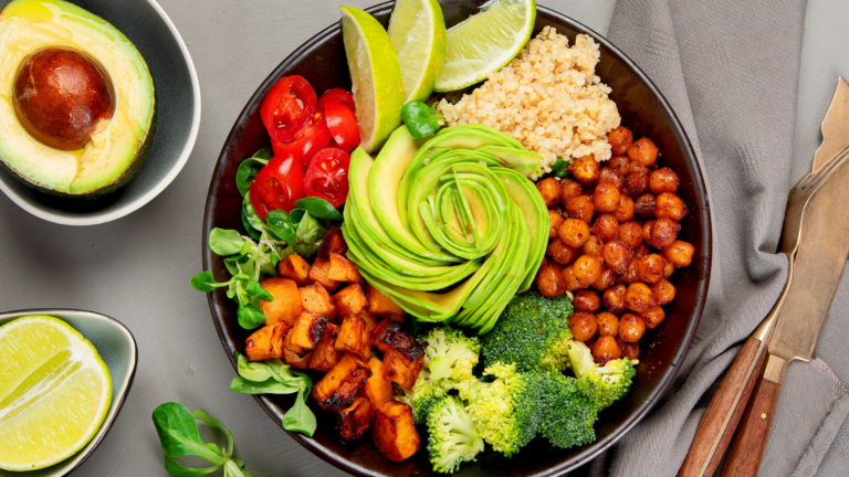 featuring creamy avocado slices, roasted chickpeas, fresh tomatoes, and bright broccoli on a bed of fluffy quinoa