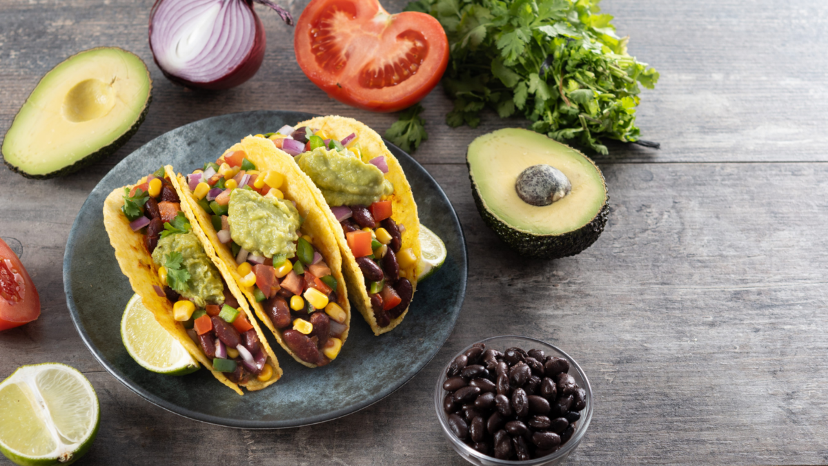 Vegan mexican Taco with beans and guacamole on wooden table