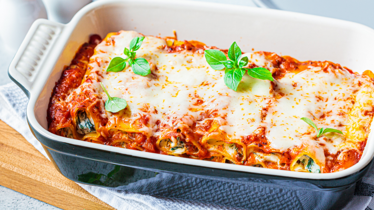Traditional ricotta and spinach cannelloni lasagna in ceramic dish. Italian food concept.