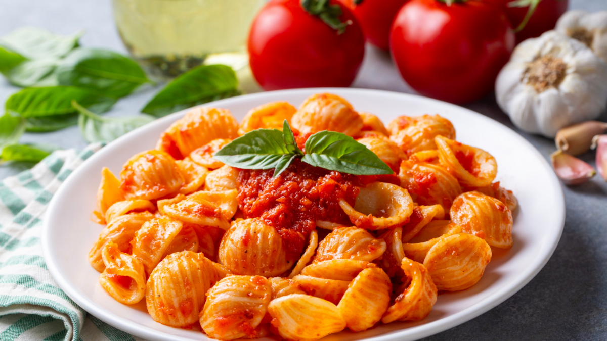 The Pasta Rule That Makes Almost Any Sauce Taste Better 1 Italian Orecchiette Pasta with Tomato Sauce and Fresh Basil Leaves Served on a White Plate