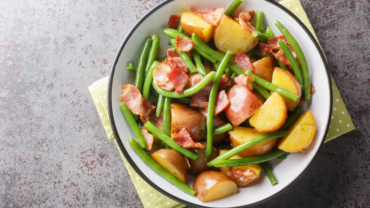 Crunchy bacon, green beans, potatoes in a vinegar dressing closeup on the plate on the table