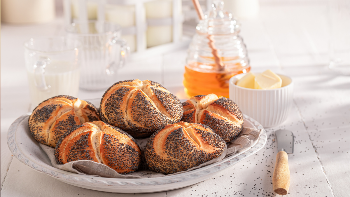 Healthy Kaiser buns with poppy seed , butter and honey. Breakfast with buns, butter and honey.